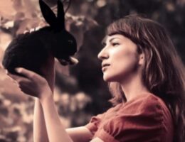 Sulla copertina de L'inverno della lepre nera di Angela Tognolini c'è la fotografia di una giovane donna che tiene tra le mani e guarda negli occhi una piccola lepre nera