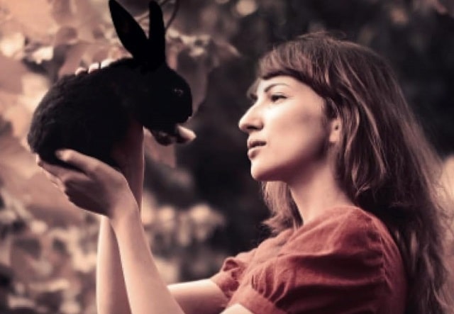 Sulla copertina de L'inverno della lepre nera di Angela Tognolini c'è la fotografia di una giovane donna che tiene tra le mani e guarda negli occhi una piccola lepre nera