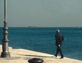 Sulla copertina de Il peso delle parole di Pascal Mercier c'è una fotografia che ritrae un uomo in abito elegante che passeggia su un molo lungo il mare
