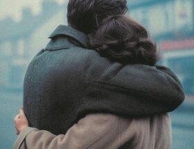 Sulla copertina di Un modo di amare di Stan Barstow ci sono un uomo e una donna di spalle, vestiti nello stile degli anni 60, che si abbracciano forte guardando verso la strada dove ci sono degli edifici