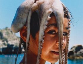 Sulla copertina di Donnaregina di Teresa Ciabatti c'è la l'immagine di un bambino al mare, che ha poggiato sui capelli un polpo